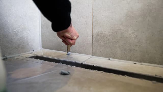 Vakman brengt strakke kitnaad aan in een badkamer in Capelle aan den IJssel